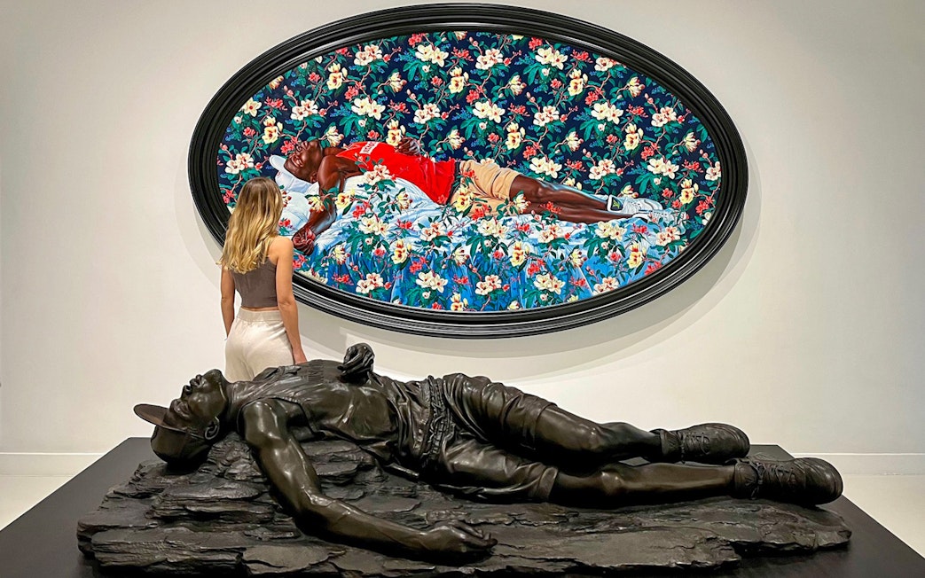 Visitor admiring art at Moco Museum, Barcelona, with a colorful painting and sculpture.