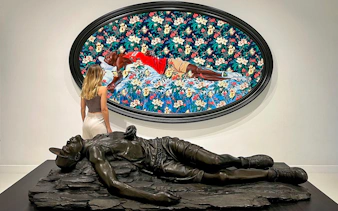 Visitor admiring art at Moco Museum, Barcelona, with a colorful painting and sculpture.