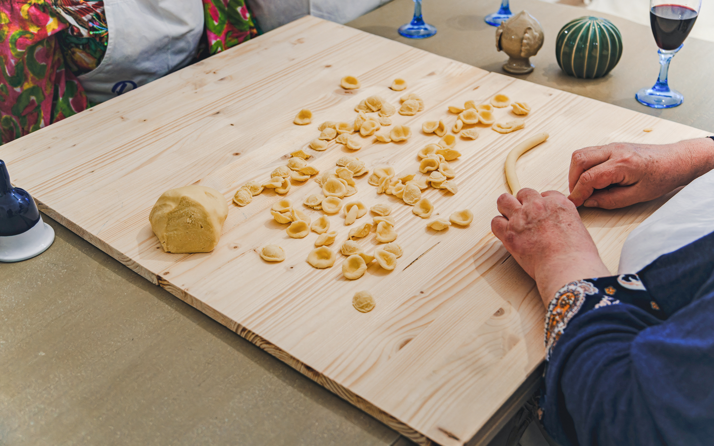 Hands shaping orecchiette pasta at Polignano a Mare cooking class.