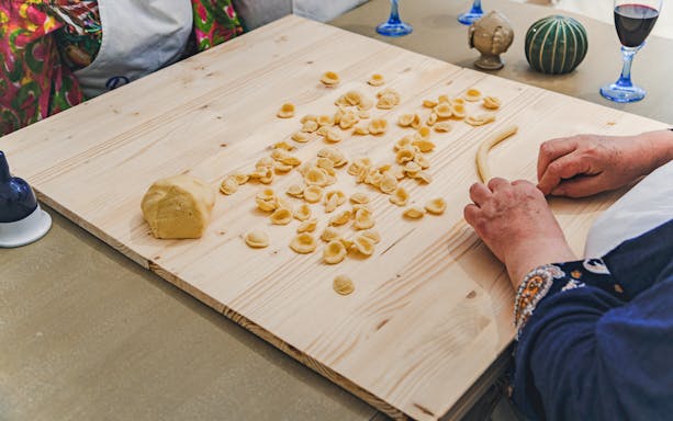 Hands shaping orecchiette pasta at Polignano a Mare cooking class.