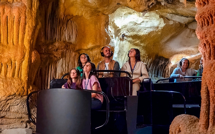 Visitors exploring Cosquer Cave in Marseille with audio guides.