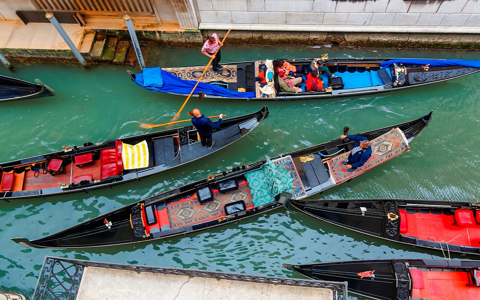 Gondolas navigating a busy canal in Venice, Italy.