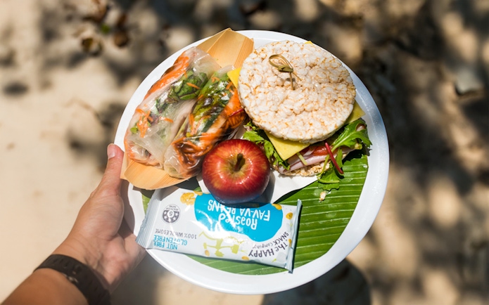 Picnic lunch with rice cakes, apple, and spring rolls at Fitzroy Island beach.
