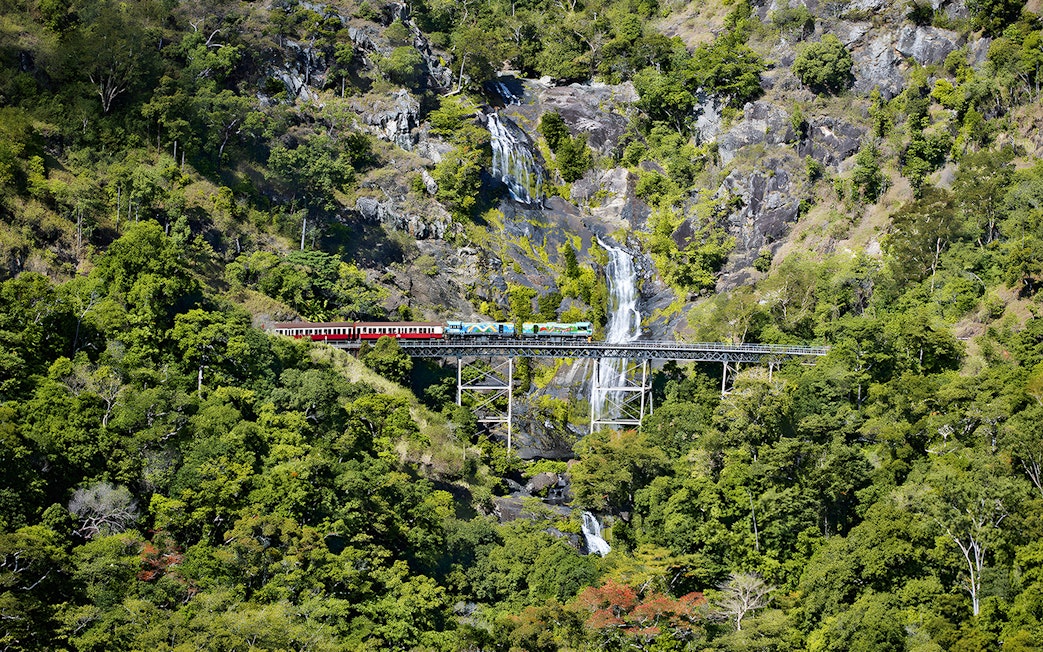 Kuranda Scenic Railway crossing Stoney Creek Falls in lush rainforest.