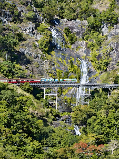 Kuranda Scenic Railway crossing Stoney Creek Falls in lush rainforest.