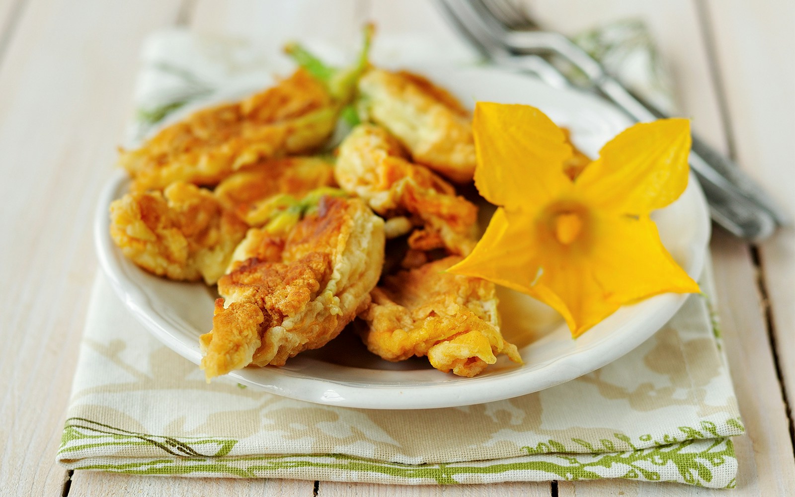 Fried zucchini flowers on a plate, showcasing a popular Italian appetizer.