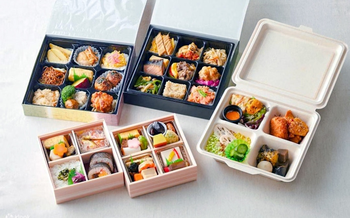 Assorted bento boxes at The Sumo Hall Hirakuza Osaka with sushi, rice, and side dishes.