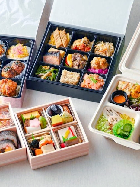 Assorted bento boxes at The Sumo Hall Hirakuza Osaka with sushi, rice, and side dishes.