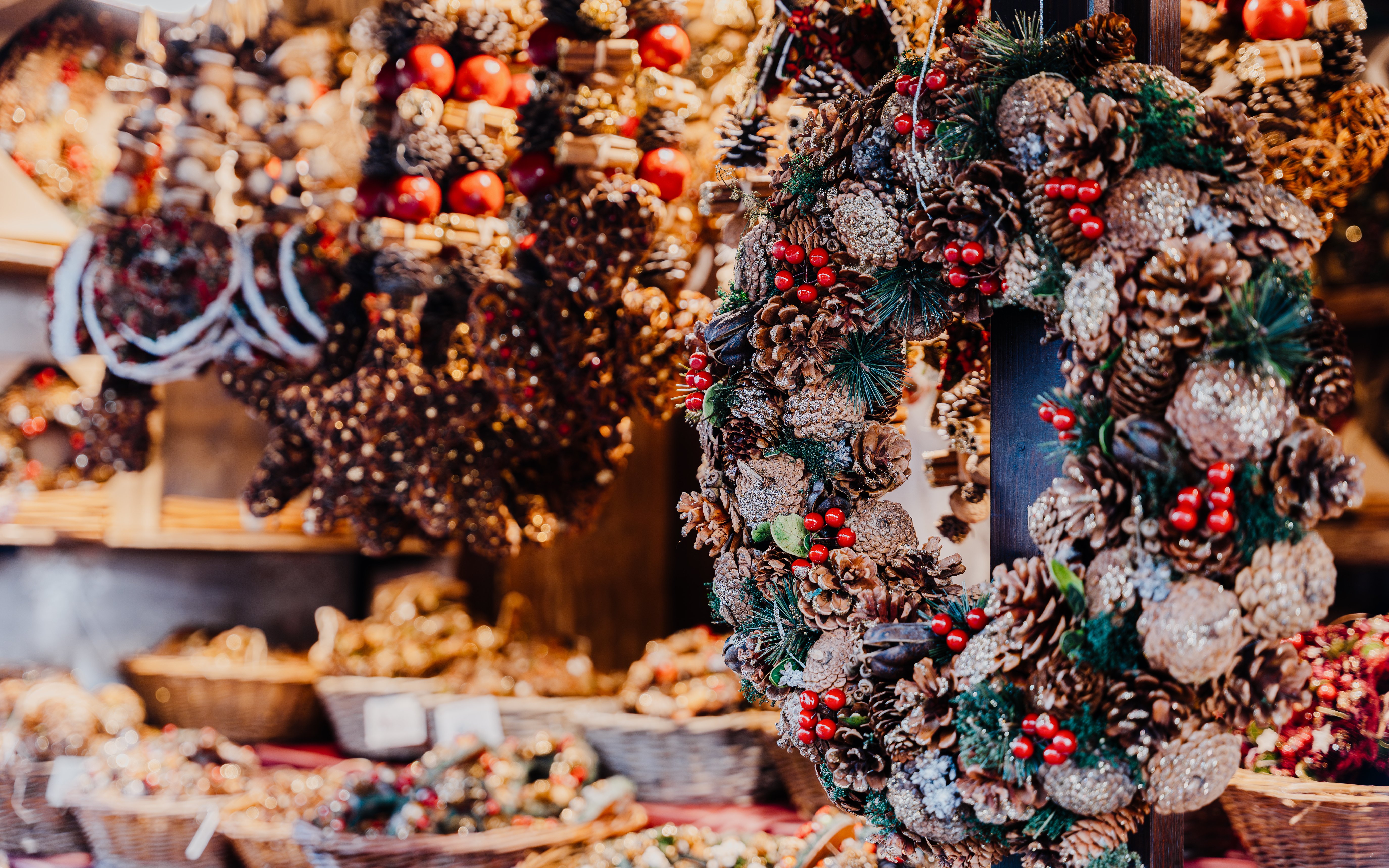 Christmas wreaths with pinecones and berries at a local market stall.