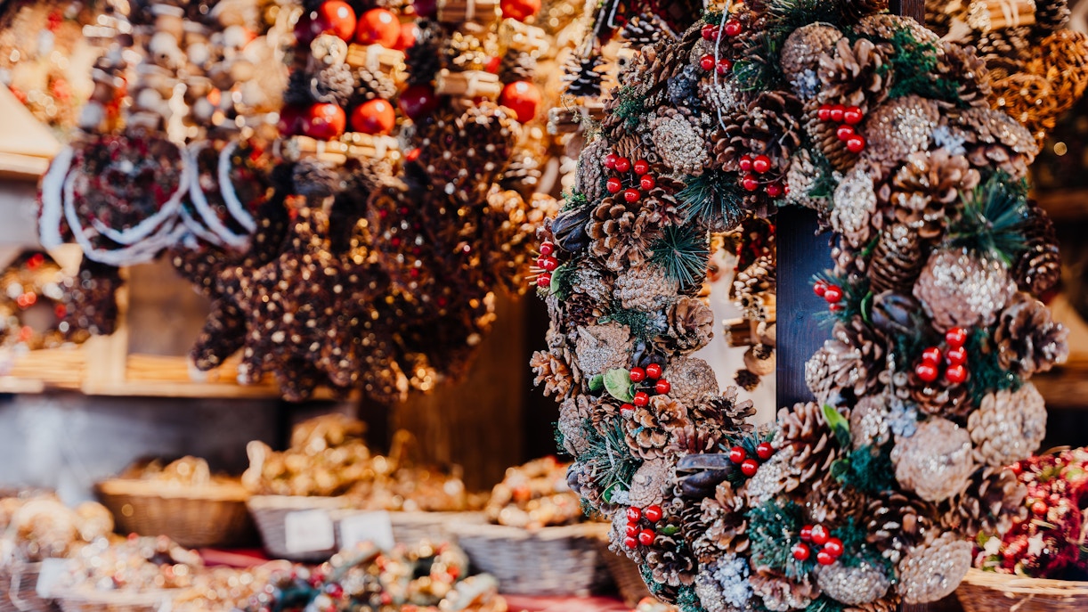 Christmas wreaths with pinecones and berries at a local market stall.