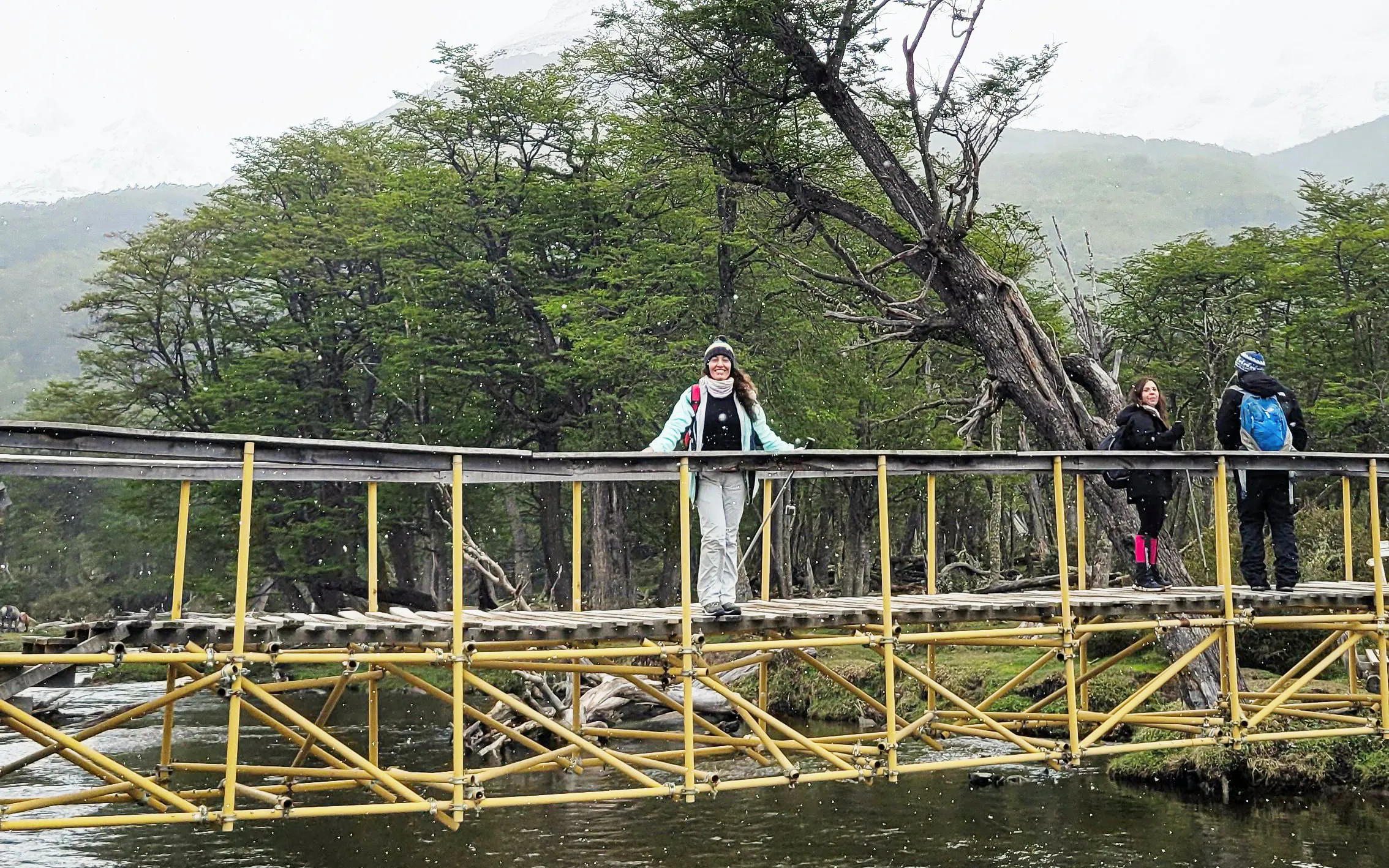 Trekking group crossing a wooden bridge in Vinciguerra Glacier, Argentina.