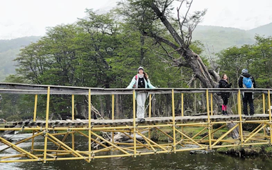 Trekking group crossing a wooden bridge in Vinciguerra Glacier, Argentina.