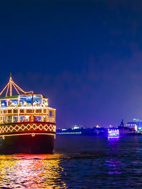 Dhow cruise with lights on Dubai Creek at night.