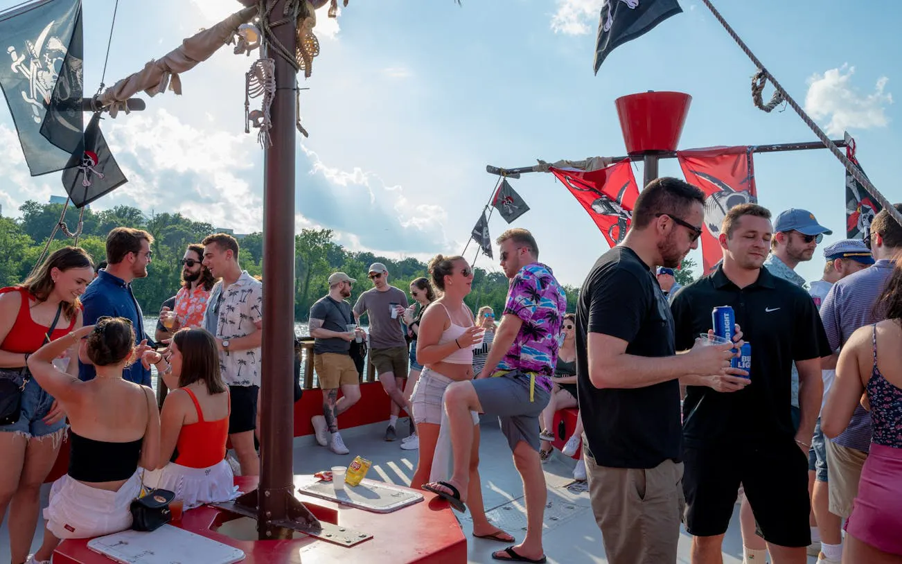 Adults enjoying a party on the Boomerang Pirate Ship with drinks and pirate flags in Washington, DC.