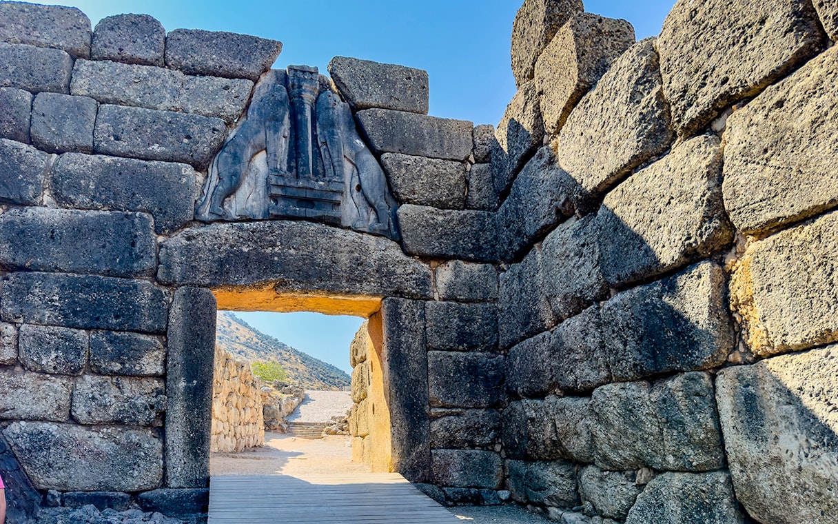 Lion Gate entrance at Mycenae archaeological site, Greece, with stone walls and relief sculpture.