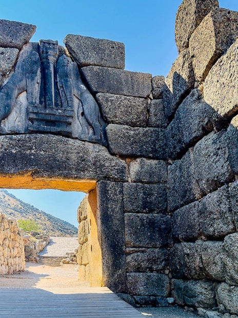 Lion Gate entrance at Mycenae archaeological site, Greece, with stone walls and relief sculpture.