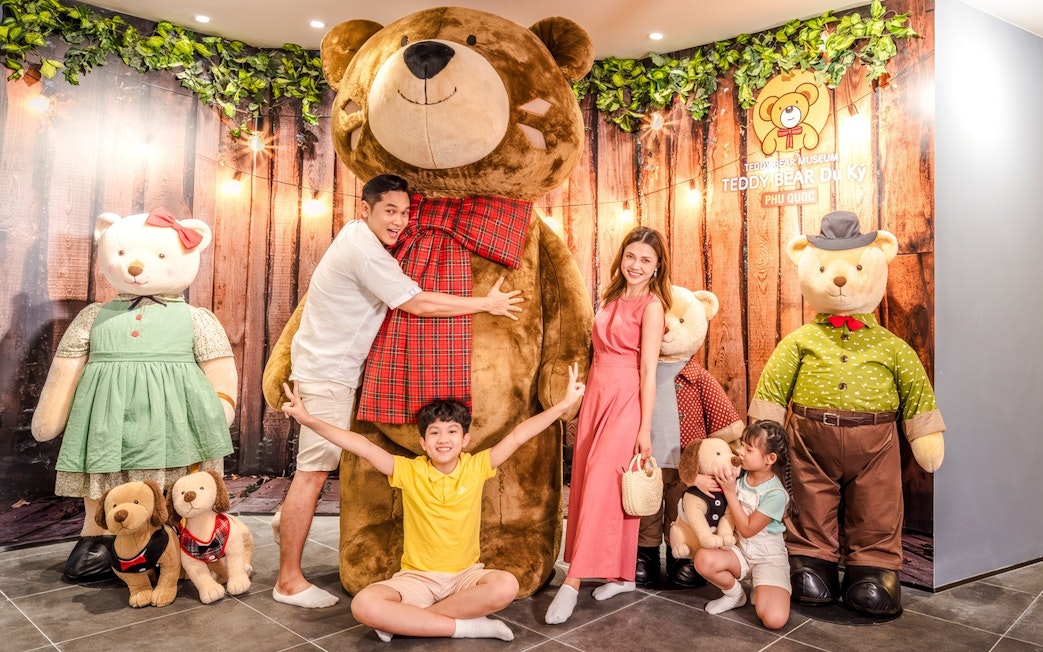 Family posing with large teddy bears at Teddy Museum, Phu Quoc.