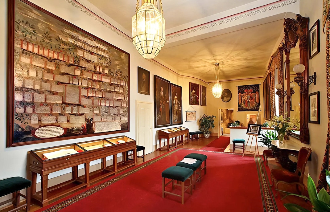 Cesky Krumlov Castle room with historical paintings and display cases.