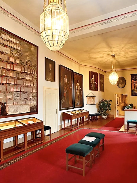 Cesky Krumlov Castle room with historical paintings and display cases.