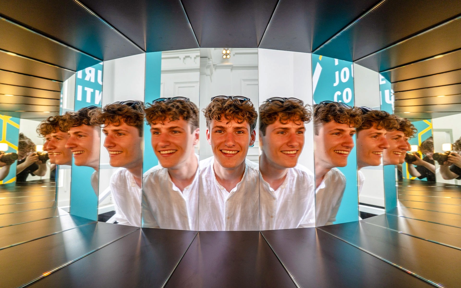 Guests interacting with mirror exhibit at Museum of Illusions Amsterdam.