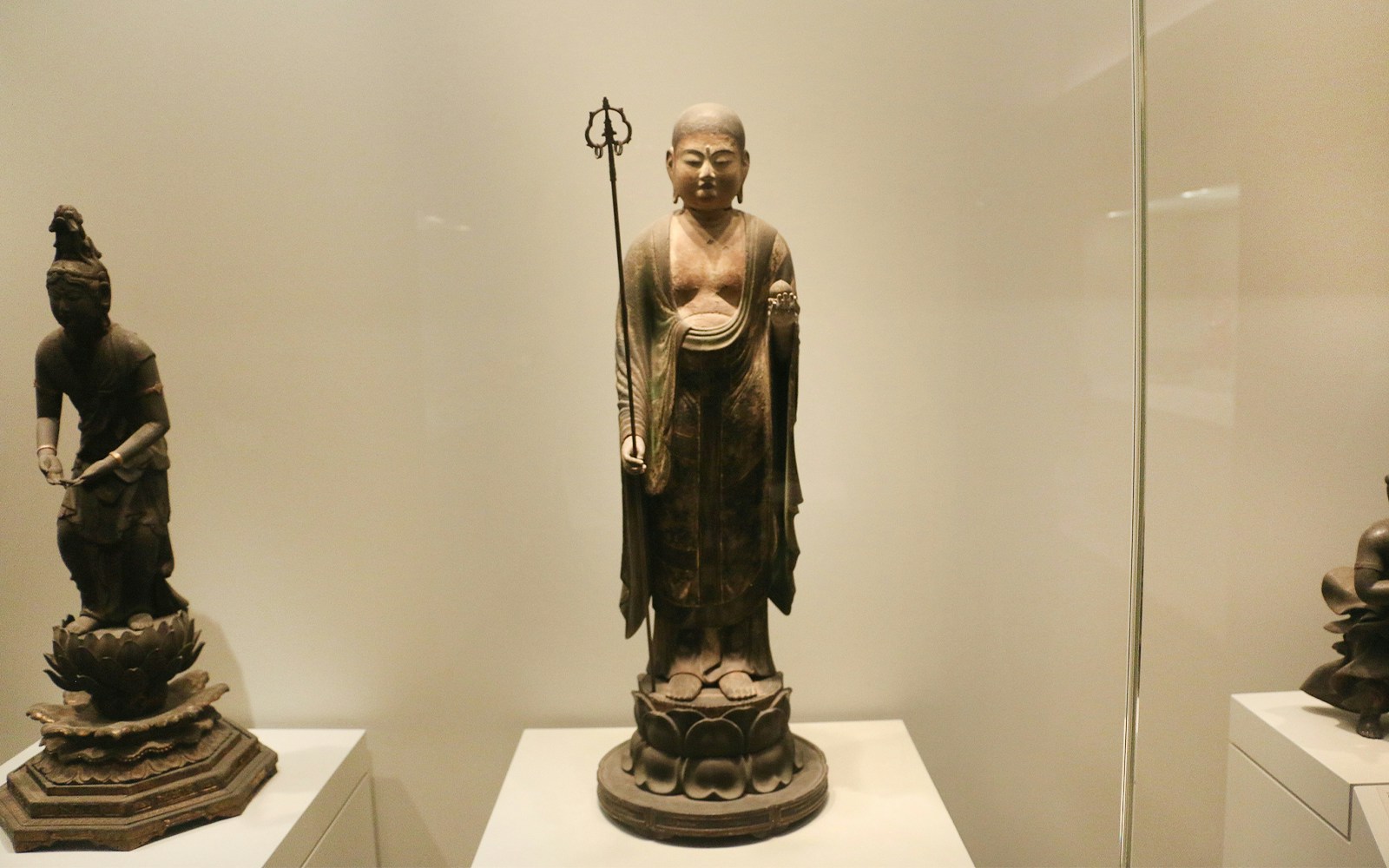 Sculpture of a standing figure holding a staff at The Art Institute of Chicago.