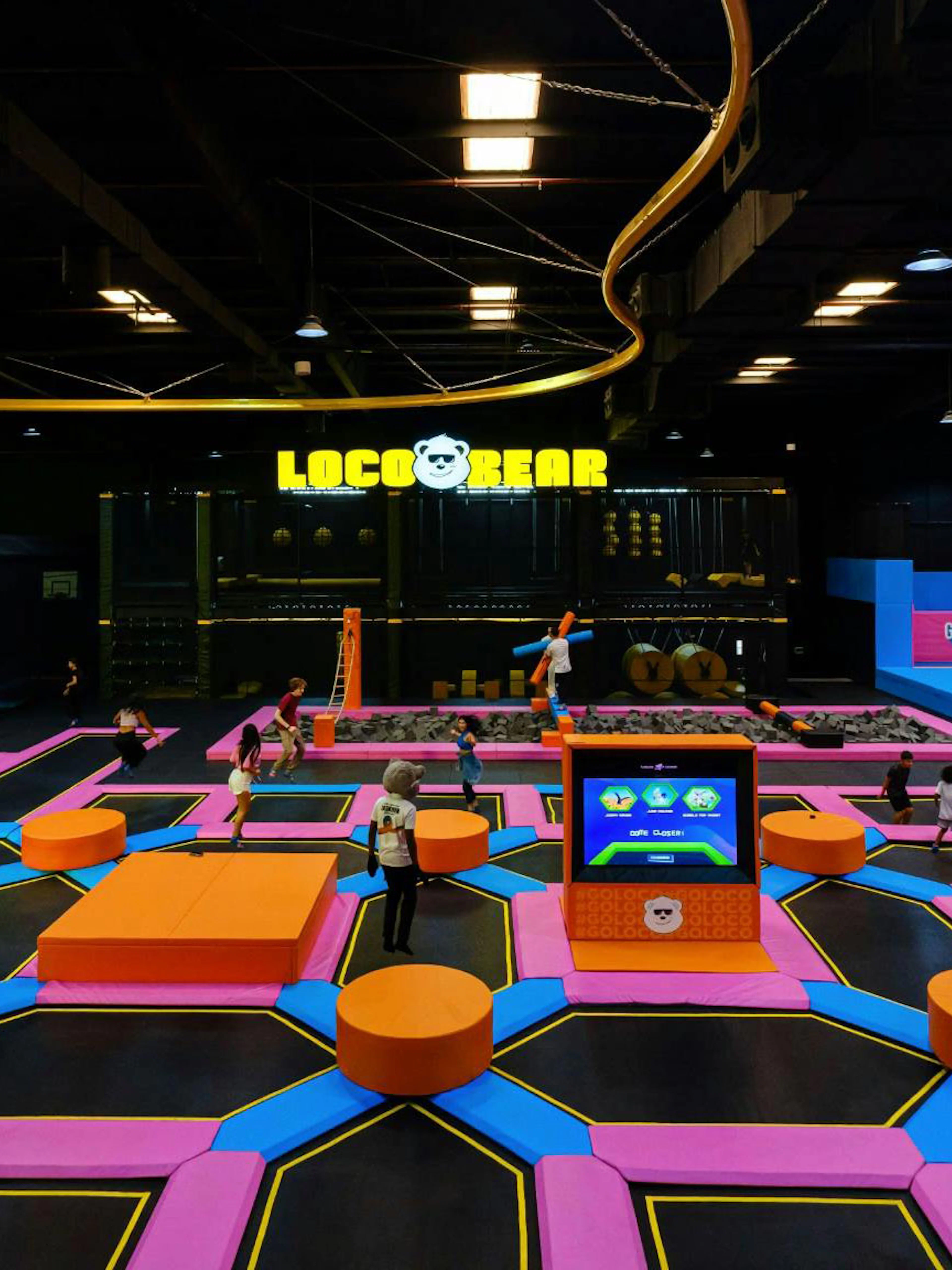 Indoor trampoline park with colorful play areas at Loco Bear, Dubai.