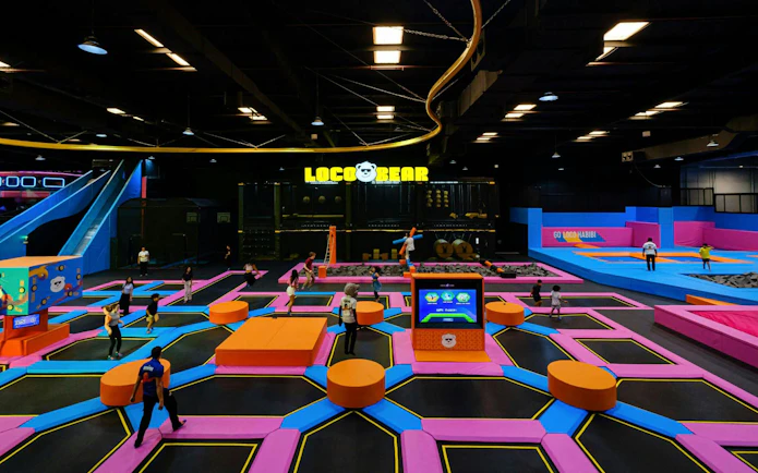 Indoor trampoline park with colorful play areas at Loco Bear, Dubai.