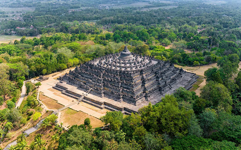 Aerial view of Borobudur Temple surrounded by lush greenery in Yogyakarta, Java, Indonesia.
