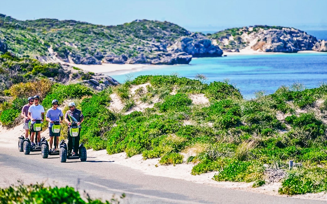 Segway tour group exploring Rottnest Island coast with ocean view.