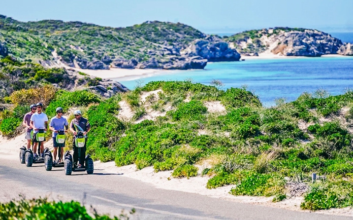Segway tour group exploring Rottnest Island coast with ocean view.