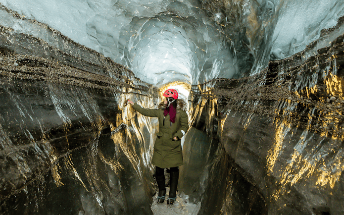 Guests exploring the icy passage of Katla Ice Cave in Iceland.