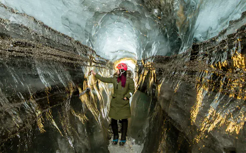 Guests exploring the icy passage of Katla Ice Cave in Iceland.