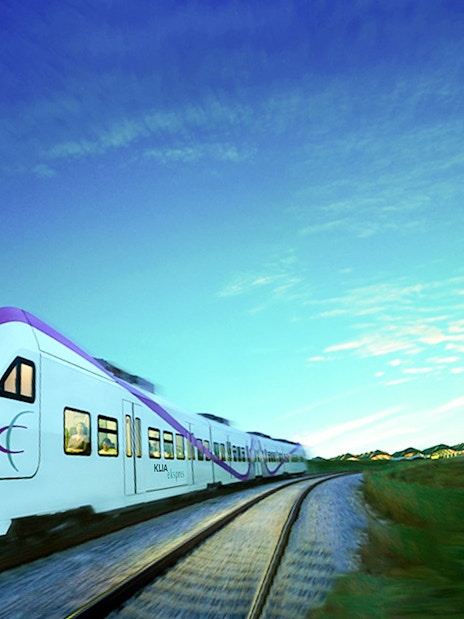 KLIA Express train traveling with control tower in the background, Malaysia.