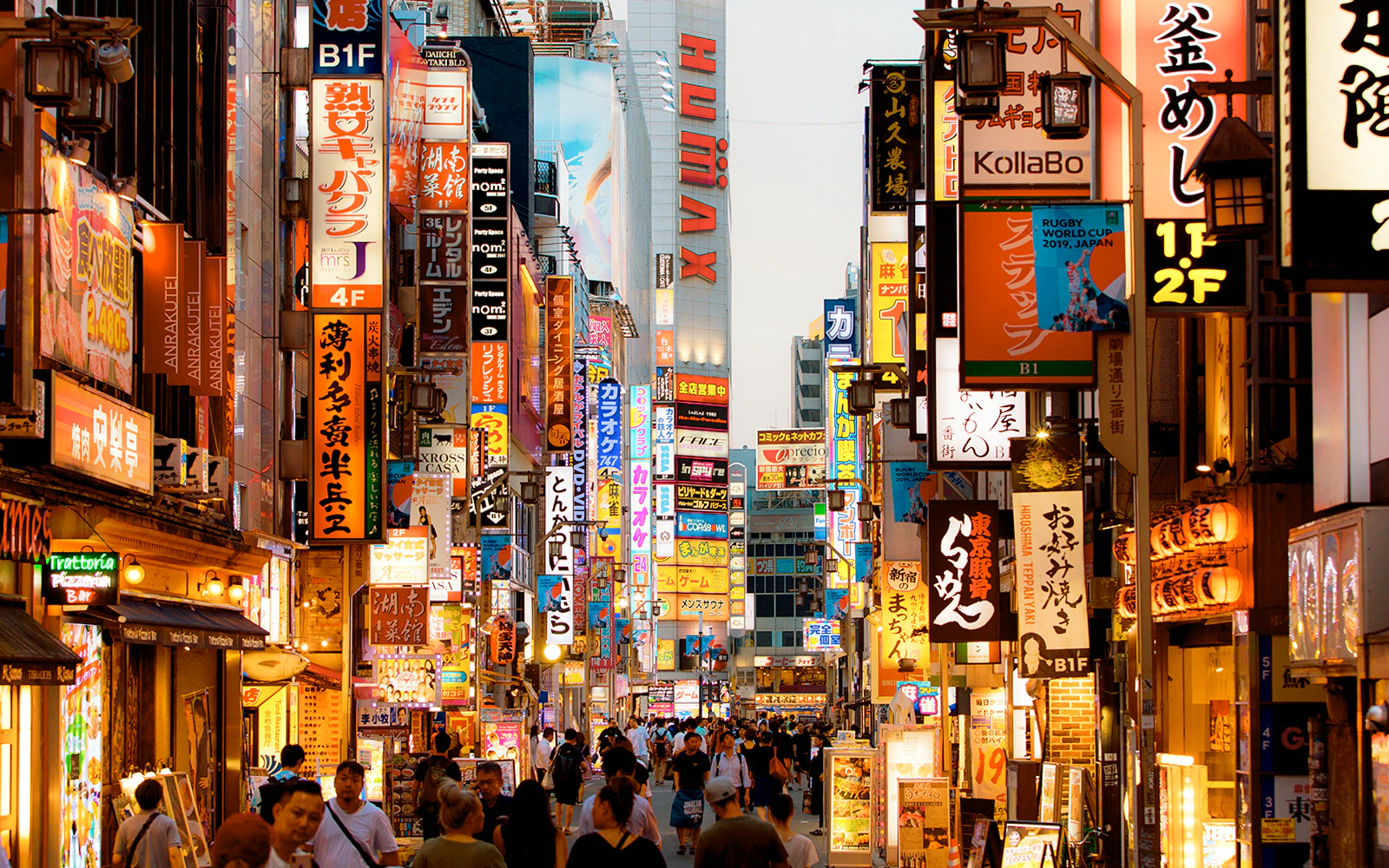 Bustling street in Tokyo downtown at night with neon signs and crowds.