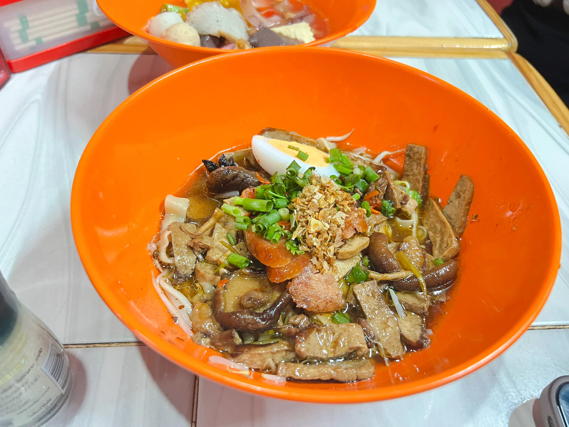 Chiang Mai noodle dish with mushrooms, egg, and herbs on Michelin Food Walking Tour.