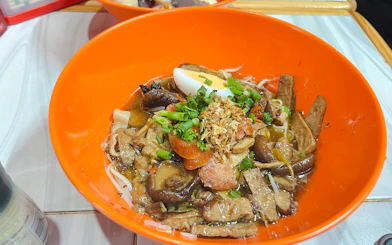 Chiang Mai noodle dish with mushrooms, egg, and herbs on Michelin Food Walking Tour.