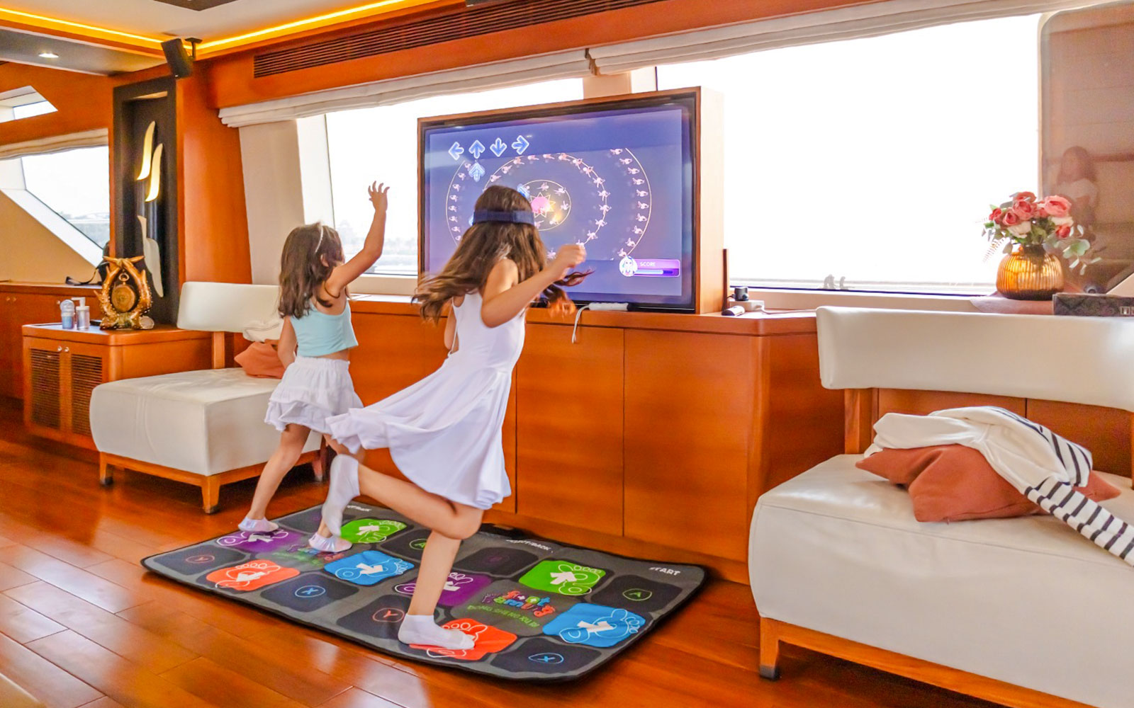Kids engaging with interactive TV games on a yacht cruise in Dubai.