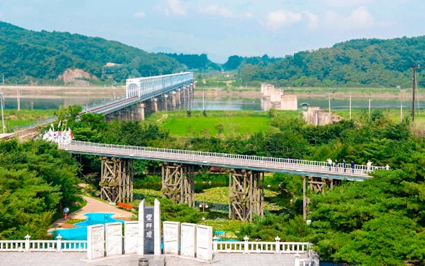 Bridge of Freedom at Korean DMZ with lush greenery and distant hills.