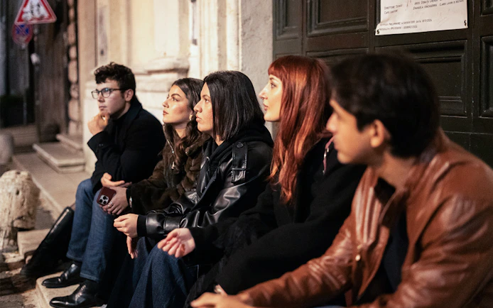Group of people listening to a guide during a haunted ghosts tour in Rome.