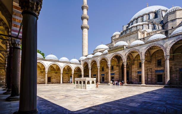 Inner courtyard of Suleymaniye Mosque with arches and central fountain, Istanbul.