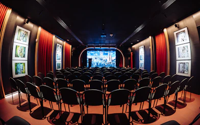 Seating area facing stage at Teatro Flamenco Barcelona with red curtains and artwork.