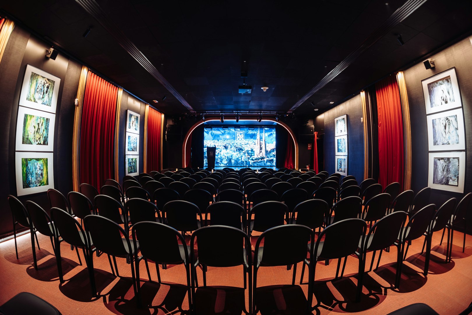 Seating area facing stage at Teatro Flamenco Barcelona with red curtains and artwork.