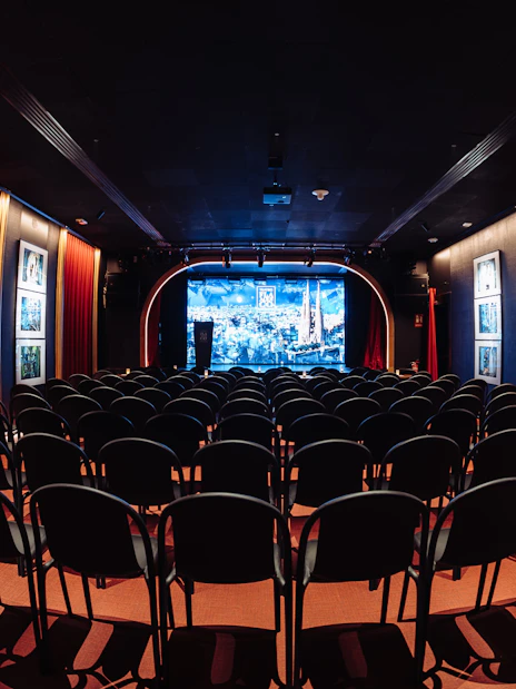 Seating area facing stage at Teatro Flamenco Barcelona with red curtains and artwork.
