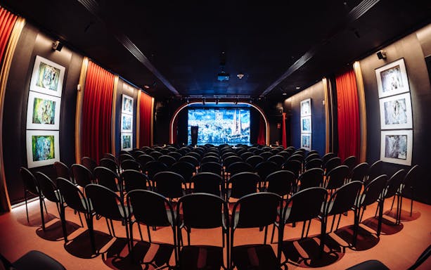 Seating area facing stage at Teatro Flamenco Barcelona with red curtains and artwork.