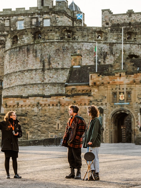 Tour guide explaining Edinburgh Castle to visitors on the Secrets of the Royal Mile Tour.