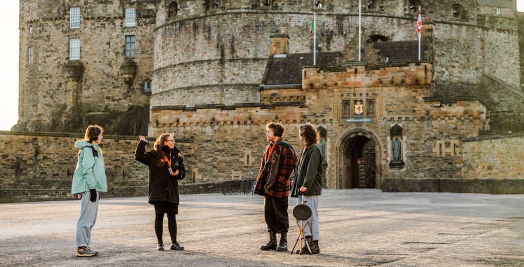 Tour guide explaining Edinburgh Castle to visitors on the Secrets of the Royal Mile Tour.