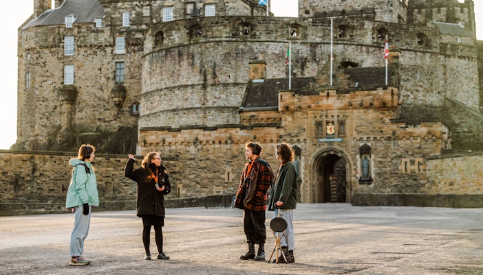 Tour guide explaining Edinburgh Castle to visitors on the Secrets of the Royal Mile Tour.