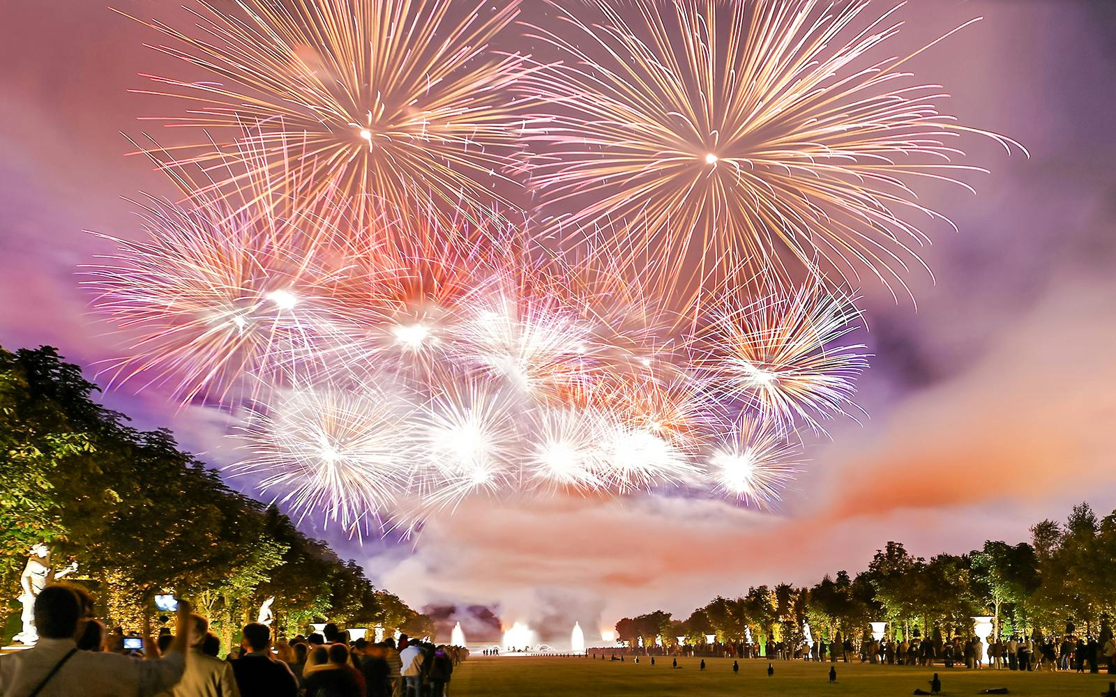 Fireworks display at Versailles Night Fountains Show with crowd watching, Paris.