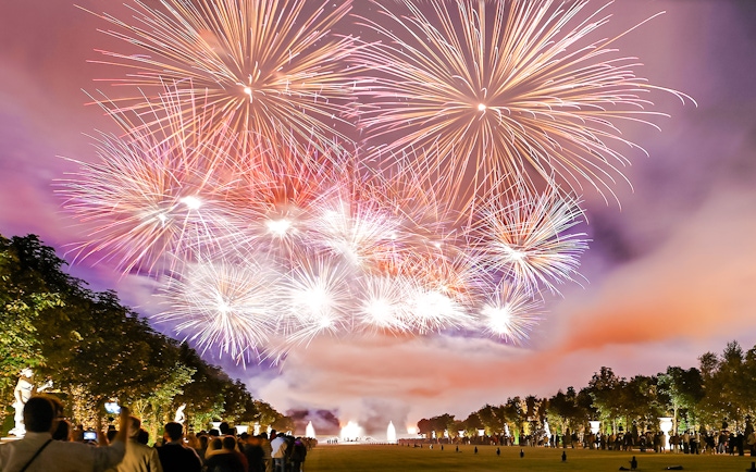 Fireworks display at Versailles Night Fountains Show with crowd watching, Paris.