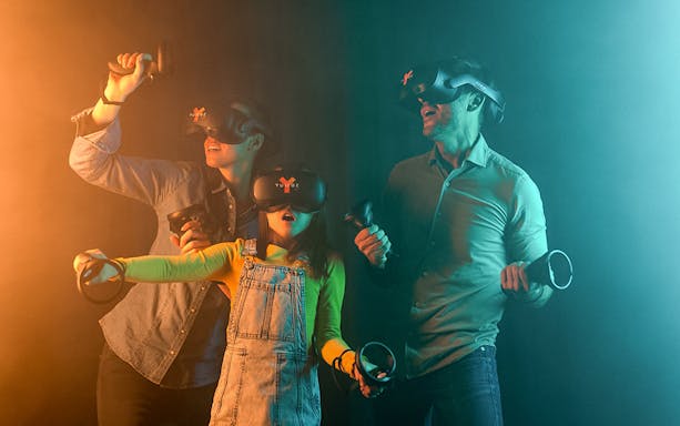 Group enjoying YULLBE GO VR experience with headsets and controllers.